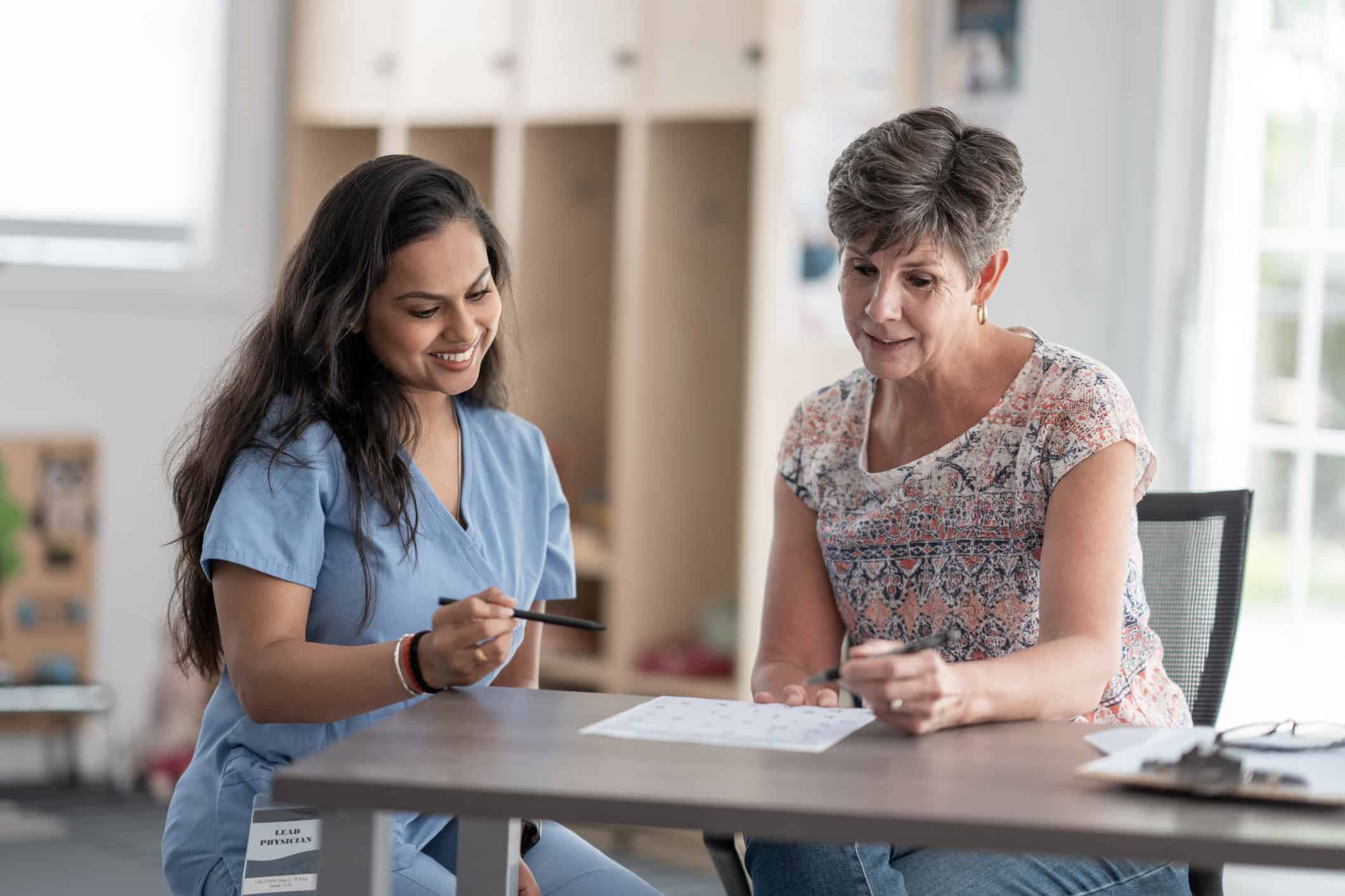 A healthcare professional provides guidance to a client, promoting wellness and improved life skills in a bright, supportive setting.